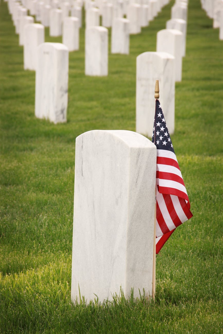 flag of u s a standing near a tombstone